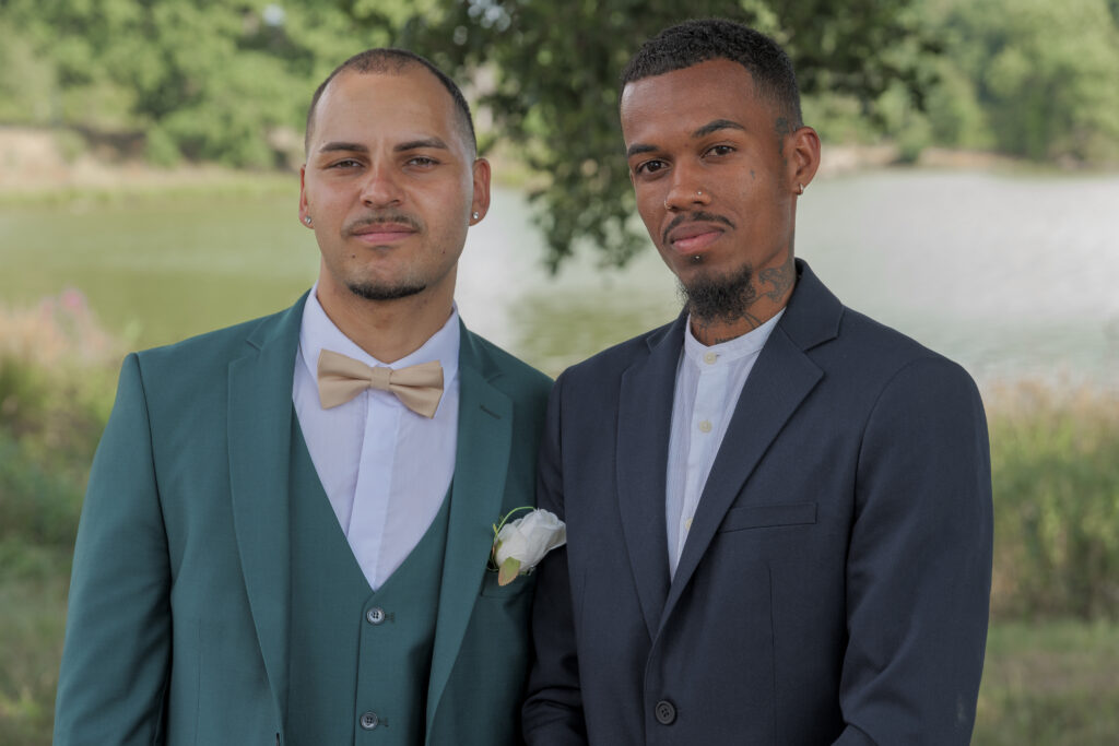 Frère du marié posant de face avec son meilleur ami lors des photos de groupe en sous-bois avec l'étang de la Cazine en arrière plan