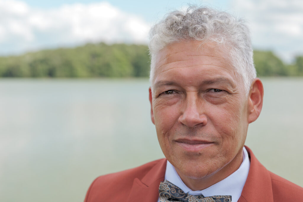 Père du marié fixant l'objectif avec en arrière plan l'étang de la Cazine de Noth.