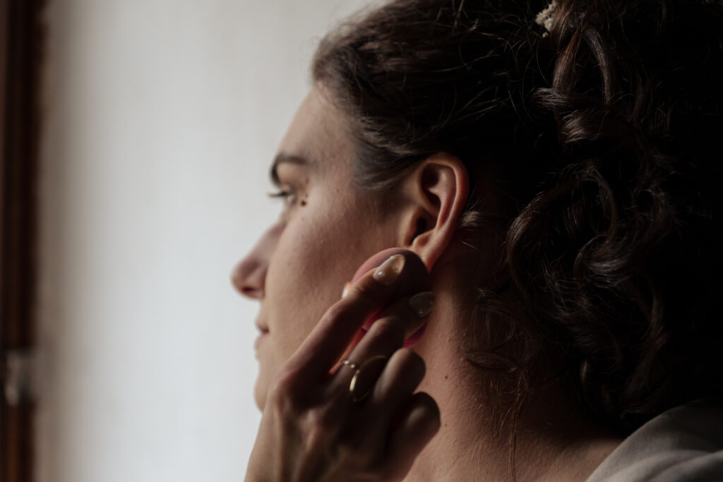 Séance maquillage de la Mariée en contre-jour et regardant par la fenêtre