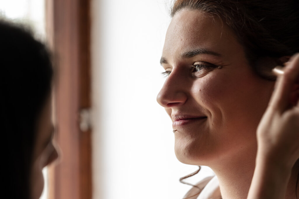 Sourire de la mariée à sa maquilleuse et amie