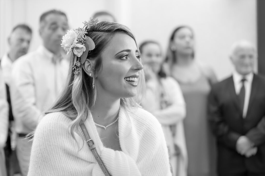 Portrait en noir et blanc de la fille d'un marié, coiffé d'une fleur dans les cheveux et d'un habillée d'un joli châle blanc