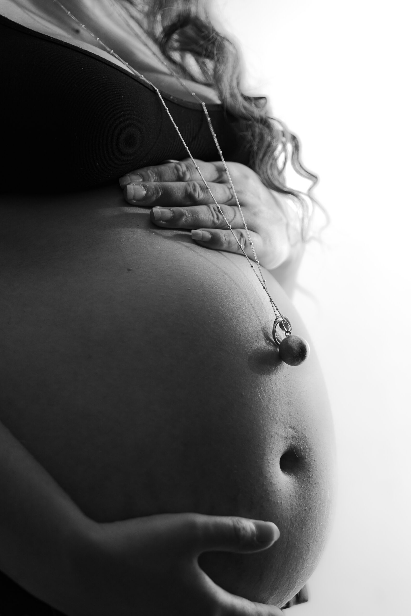 Plan rapproché en noir et blanc du ventre d'une future mère mettant en valeur un bola 